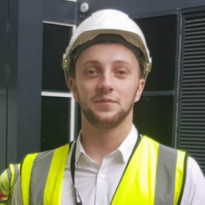 Headshot of Ryan Wheeler in a hardhat and flourescent jacket on a building site